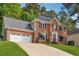 Stunning two-story brick house with an attached garage and long driveway leading to the front door at 431 Shore Dr, Suwanee, GA 30024
