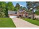 Gorgeous two-story brick home featuring a lush lawn and an attached two-car garage with a driveway at 431 Shore Dr, Suwanee, GA 30024