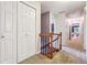 Hallway with carpeted floor, white walls, storage closets and black wrought iron railing at 431 Shore Dr, Suwanee, GA 30024