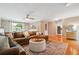 Open-concept living room with hardwood floors, a ceiling fan, and a large sofa at 431 Shore Dr, Suwanee, GA 30024