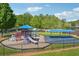 Fenced playground featuring slides, swings, and climbing equipment with ample shade from mature trees at 431 Shore Dr, Suwanee, GA 30024