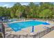 Large community pool with plenty of lounge chairs and umbrellas for a relaxing outdoor experience at 431 Shore Dr, Suwanee, GA 30024