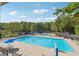 Relaxing community pool surrounded by lounge chairs, mature trees, and blue umbrellas at 431 Shore Dr, Suwanee, GA 30024