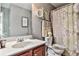 A well-maintained bathroom with a framed mirror, a floral shower curtain, and vanity at 5447 Stirrup Way, Powder Springs, GA 30127