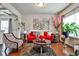 Bright and airy living area showcasing hardwood floors, a red sofa and decorative accents at 5447 Stirrup Way, Powder Springs, GA 30127