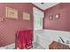Bathroom with wallpaper, a bright window, framed art, and a large soaking tub at 865 Turner Dr, Lawrenceville, GA 30046