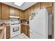 Functional kitchen featuring wood cabinets, white appliances, and ample counter space at 865 Turner Dr, Lawrenceville, GA 30046