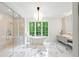 Bright bathroom featuring a freestanding tub, glass-enclosed shower, and stylish marble flooring at 5260 Long Island Nw Dr, Atlanta, GA 30327