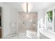 Luxurious bathroom with a glass-enclosed shower, soaking tub, and marble flooring for a serene experience at 5260 Long Island Nw Dr, Atlanta, GA 30327