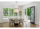 Elegant dining room with a modern chandelier, round table, and views of the backyard at 5260 Long Island Nw Dr, Atlanta, GA 30327