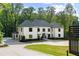 Elegant white home featuring a circular driveway, manicured lawn, and attached garage at 5260 Long Island Nw Dr, Atlanta, GA 30327