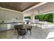Fully equipped outdoor kitchen and dining space overlooking a serene backyard with a pool at 5260 Long Island Nw Dr, Atlanta, GA 30327