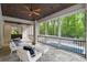 Inviting screened-in porch with stone floors, wood ceiling, stylish furniture, and pool view at 5260 Long Island Nw Dr, Atlanta, GA 30327