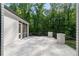 Outdoor patio with white brick and stone flooring overlooking large mature trees in the backyard at 5260 Long Island Nw Dr, Atlanta, GA 30327