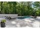 A pristine pool is surrounded by a tile patio and lounge seating in a luxurious backyard at 5260 Long Island Nw Dr, Atlanta, GA 30327