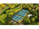 Aerial view of community tennis courts surrounded by mature trees and lush landscaping, perfect for recreation at 5260 Long Island Nw Dr, Atlanta, GA 30327