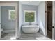 Bright bathroom with a freestanding soaking tub and a glass-enclosed shower at 613 Nebo Rd, Dallas, GA 30157