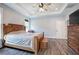 Bright, spacious bedroom with a tray ceiling, wood bed frame and dark wood-look flooring at 613 Nebo Rd, Dallas, GA 30157