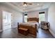 Bright bedroom featuring a wood bed frame, tray ceiling, and dark wood-look floors at 613 Nebo Rd, Dallas, GA 30157
