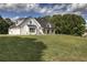 Charming two-story home with white siding, and a three car garage surrounded by a lush green lawn and mature trees at 613 Nebo Rd, Dallas, GA 30157