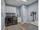 Laundry room with front load washer and dryer, storage cabinets, countertop, and blue walls at 613 Nebo Rd, Dallas, GA 30157