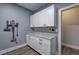 This mudroom features ample storage with sleek white cabinetry and light granite countertops for added functionality at 613 Nebo Rd, Dallas, GA 30157