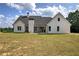 View of the rear exterior showcasing the covered patio, well maintained lawn, and classic architectural design at 613 Nebo Rd, Dallas, GA 30157