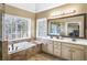 Luxurious ensuite bathroom features a soaking tub, dual vanities, and a glass enclosed shower at 893 Brookgreen Pl, Lawrenceville, GA 30043