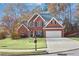 Charming two-story brick home features a well-manicured lawn, two-car garage, and mature trees at 893 Brookgreen Pl, Lawrenceville, GA 30043