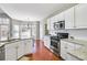 Modern kitchen with white cabinets, granite countertops, stainless appliances, and a breakfast nook at 893 Brookgreen Pl, Lawrenceville, GA 30043