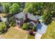 An aerial view showcases this property's brick architecture, in-ground pool and surrounding mature trees at 225 Farmbrooke Ct, Sandy Springs, GA 30350