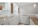 Basement bar with marble countertops, white cabinetry, glass shelving, and mini fridge at 225 Farmbrooke Ct, Sandy Springs, GA 30350