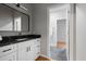 Modern bathroom featuring a black marble countertop, white cabinets and a view to another bathroom at 225 Farmbrooke Ct, Sandy Springs, GA 30350