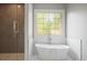 Soaking tub under a stained glass window next to a walk-in shower with herringbone tile at 225 Farmbrooke Ct, Sandy Springs, GA 30350