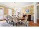 Formal dining room boasts hardwood floors, designer wallpaper, elegant chandelier, and plantation shutters at 225 Farmbrooke Ct, Sandy Springs, GA 30350