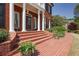 Stately brick home entrance with elegant column supports and brick steps leading to a covered porch at 225 Farmbrooke Ct, Sandy Springs, GA 30350