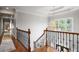 Open hallway with hardwood floors and wrought iron banister at 225 Farmbrooke Ct, Sandy Springs, GA 30350