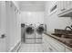 Spacious laundry room with granite counters, white cabinets, and modern washer/dryer at 225 Farmbrooke Ct, Sandy Springs, GA 30350