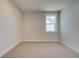 Well-lit, neutral-toned bedroom featuring plush carpeting and ample natural light from a single window at 4730 Montane St, Cumming, GA 30028