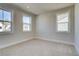 Bright bedroom featuring two windows with neighborhood views and neutral colored walls and carpets at 4730 Montane St, Cumming, GA 30028