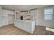 Bright modern kitchen featuring an island, white cabinetry, stainless appliances, and wood look floors at 4730 Montane St, Cumming, GA 30028