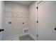 Practical laundry room with tile floors, shelving and modern hookups for washer and dryer at 4730 Montane St, Cumming, GA 30028