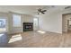 Bright living room with fireplace, wood floors, ceiling fan, and large windows at 4730 Montane St, Cumming, GA 30028