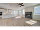 Open-concept living room with wood floors, a fireplace, and ample natural light from large windows at 4730 Montane St, Cumming, GA 30028