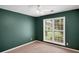 Inviting bedroom featuring a large window and soothing green walls, creating a peaceful atmosphere for rest and relaxation at 5410 Lenox Park Pl, Buford, GA 30518