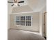 Bright bedroom featuring a vaulted ceiling, large windows, and neutral tones, creating a calming and inviting atmosphere at 5410 Lenox Park Pl, Buford, GA 30518
