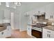 Modern kitchen with stainless steel appliances, white cabinets, granite countertops, and hardwood floors at 5410 Lenox Park Pl, Buford, GA 30518
