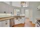 Bright kitchen featuring white cabinets, a stainless steel sink, appliances, and beautiful hardwood floors, offering a modern space at 5410 Lenox Park Pl, Buford, GA 30518