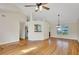 Open living room with hardwood floors, a ceiling fan, and natural light from a large window at 5410 Lenox Park Pl, Buford, GA 30518