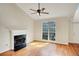 Cozy living room featuring a fireplace, hardwood floors, and a large window providing natural light at 5410 Lenox Park Pl, Buford, GA 30518